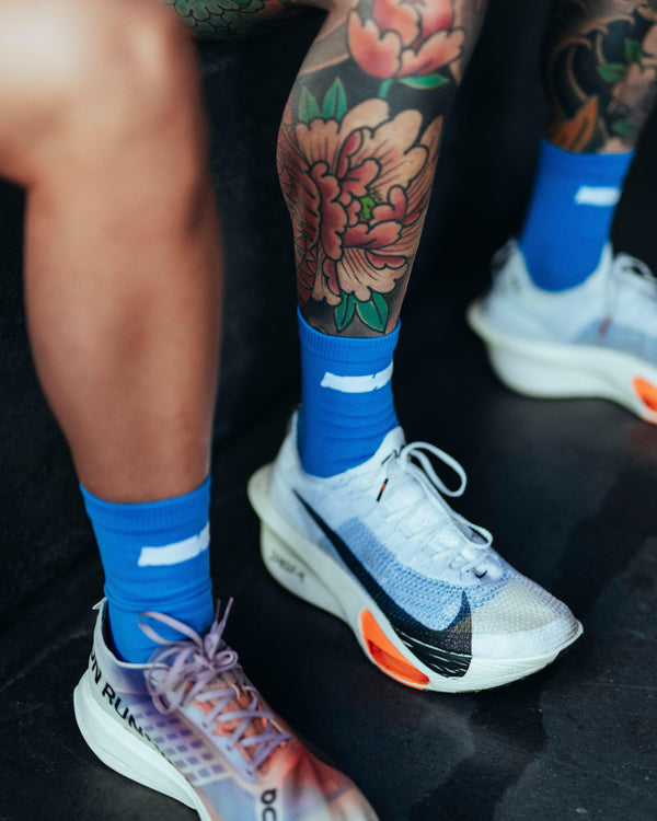 Blue Race Sock worn by runner showing snug fit and lightweight design